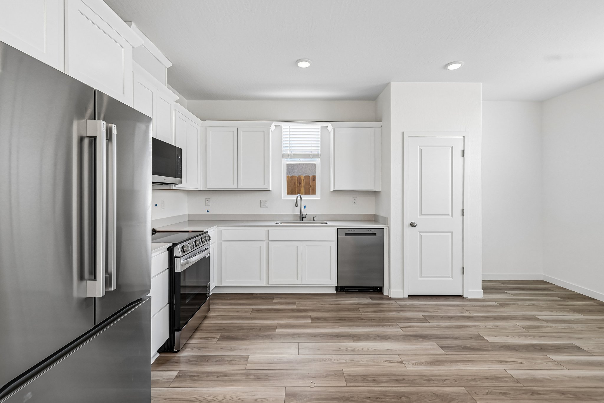 A kitchen with white cabinets.
