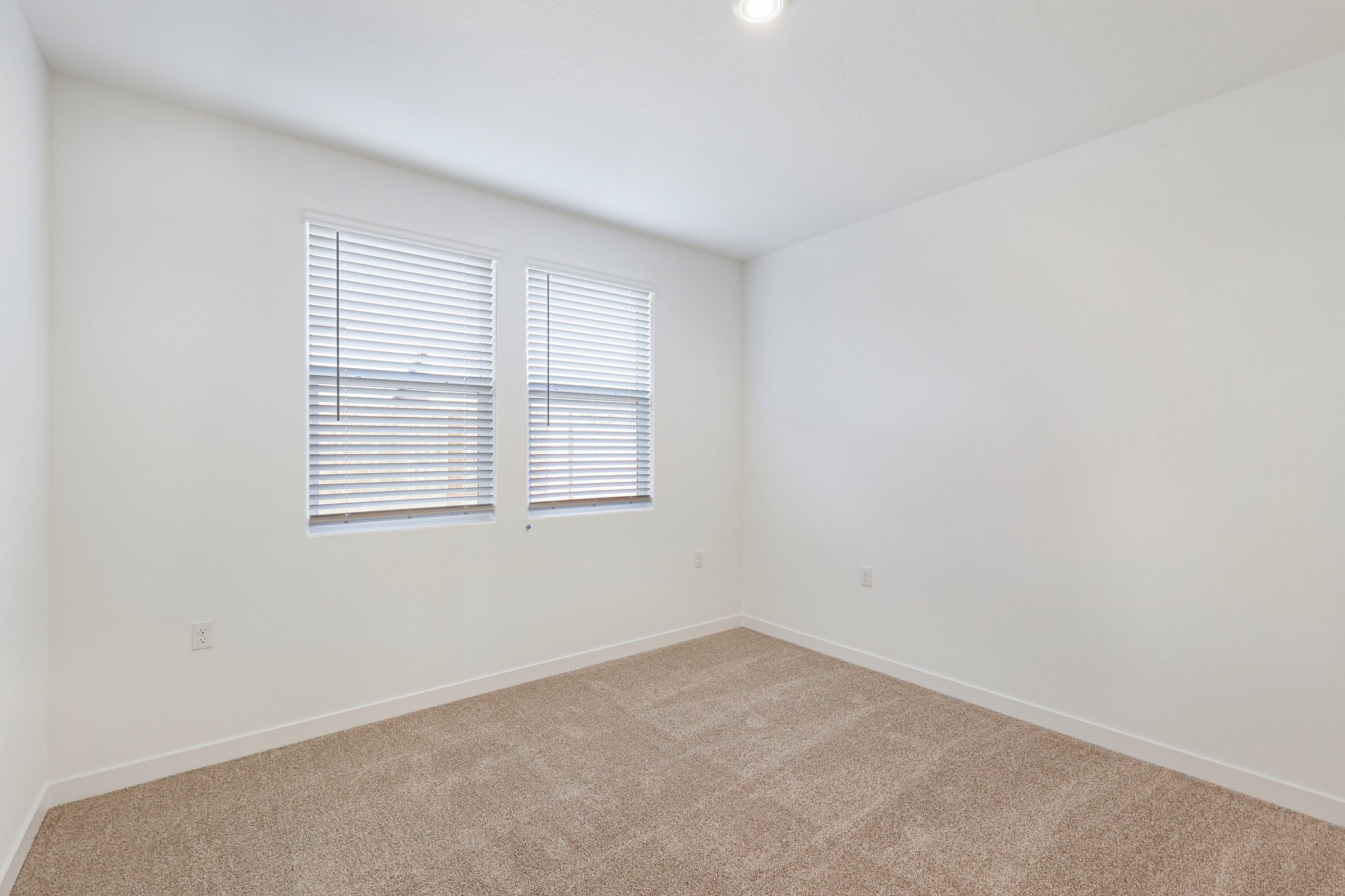 A room with a carpet and a window.