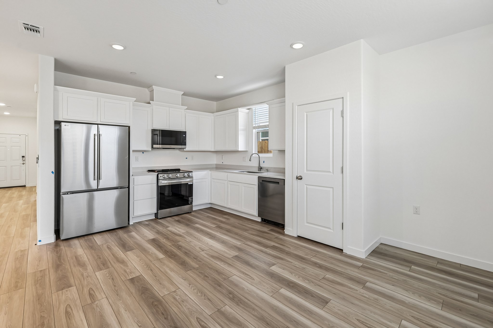 A kitchen with white cabinets.