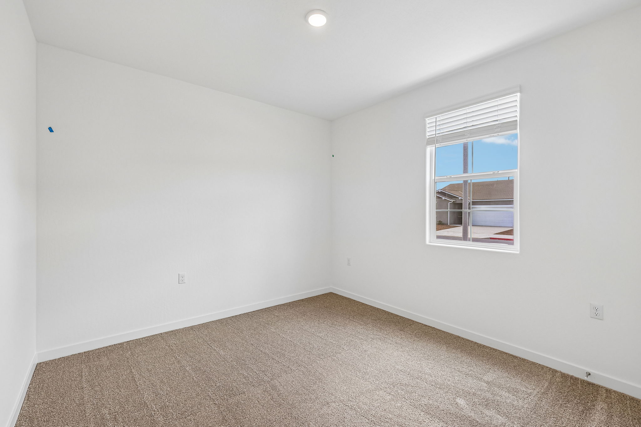 A room with a window and carpet.