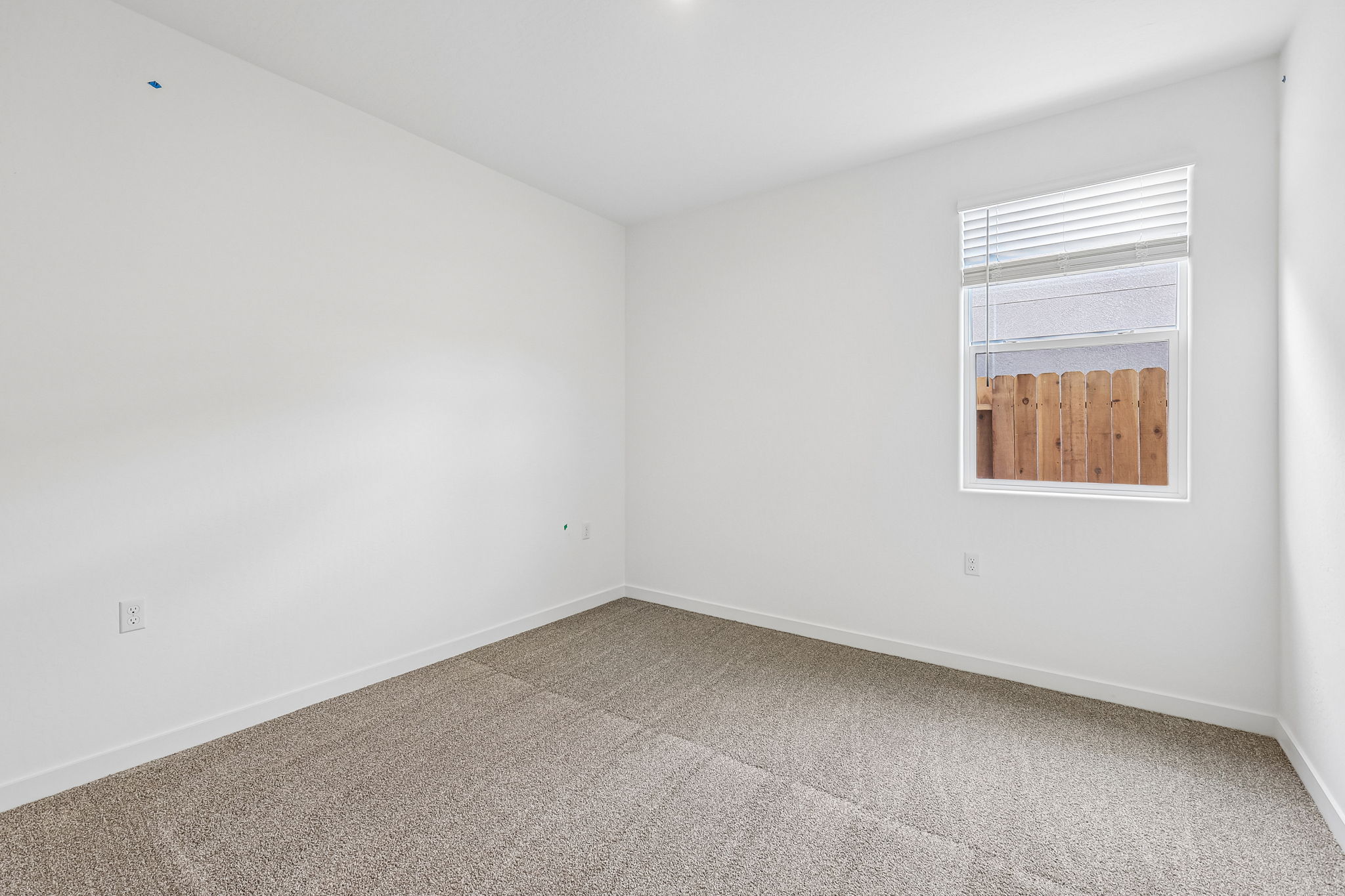 A room with a window and a rug.