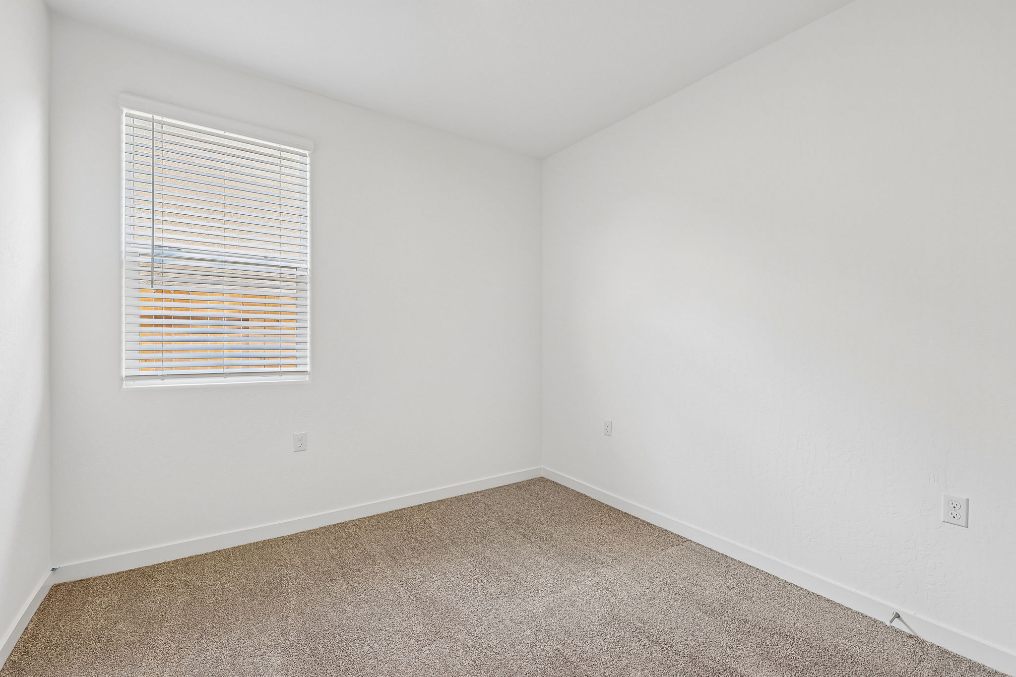 A room with a window and carpet.