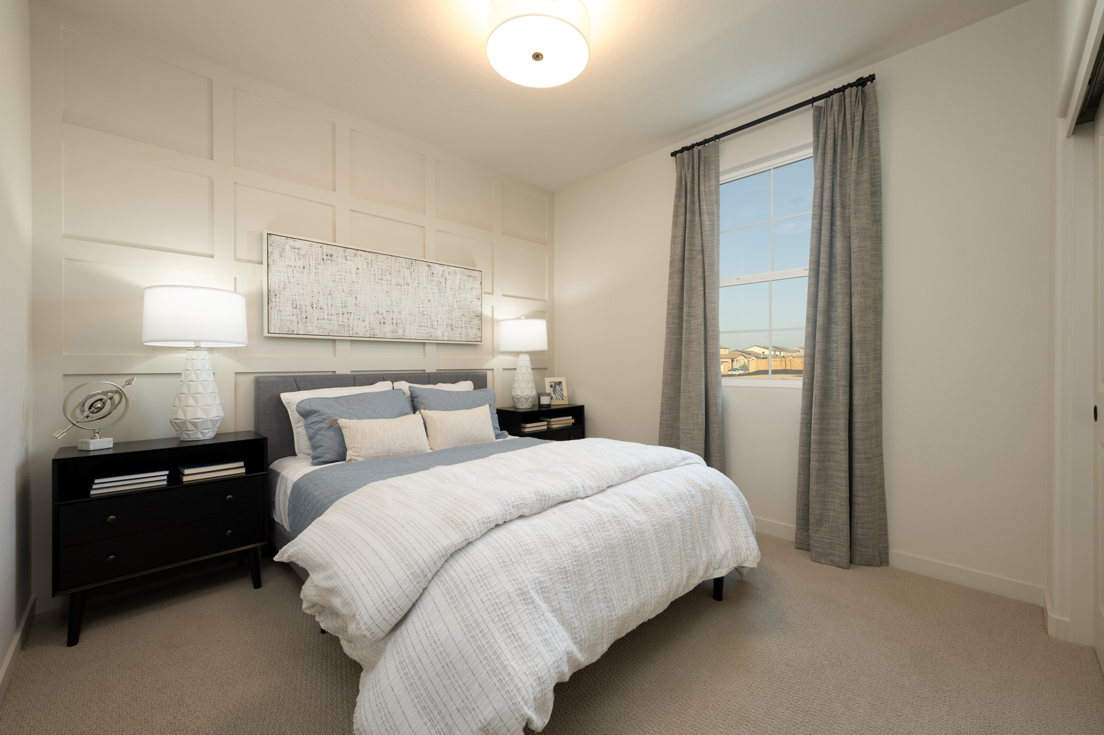 A bedroom with a large window.