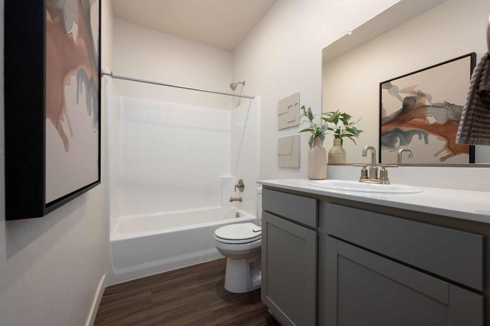 A bathroom with a sink toilet and a mirror.
