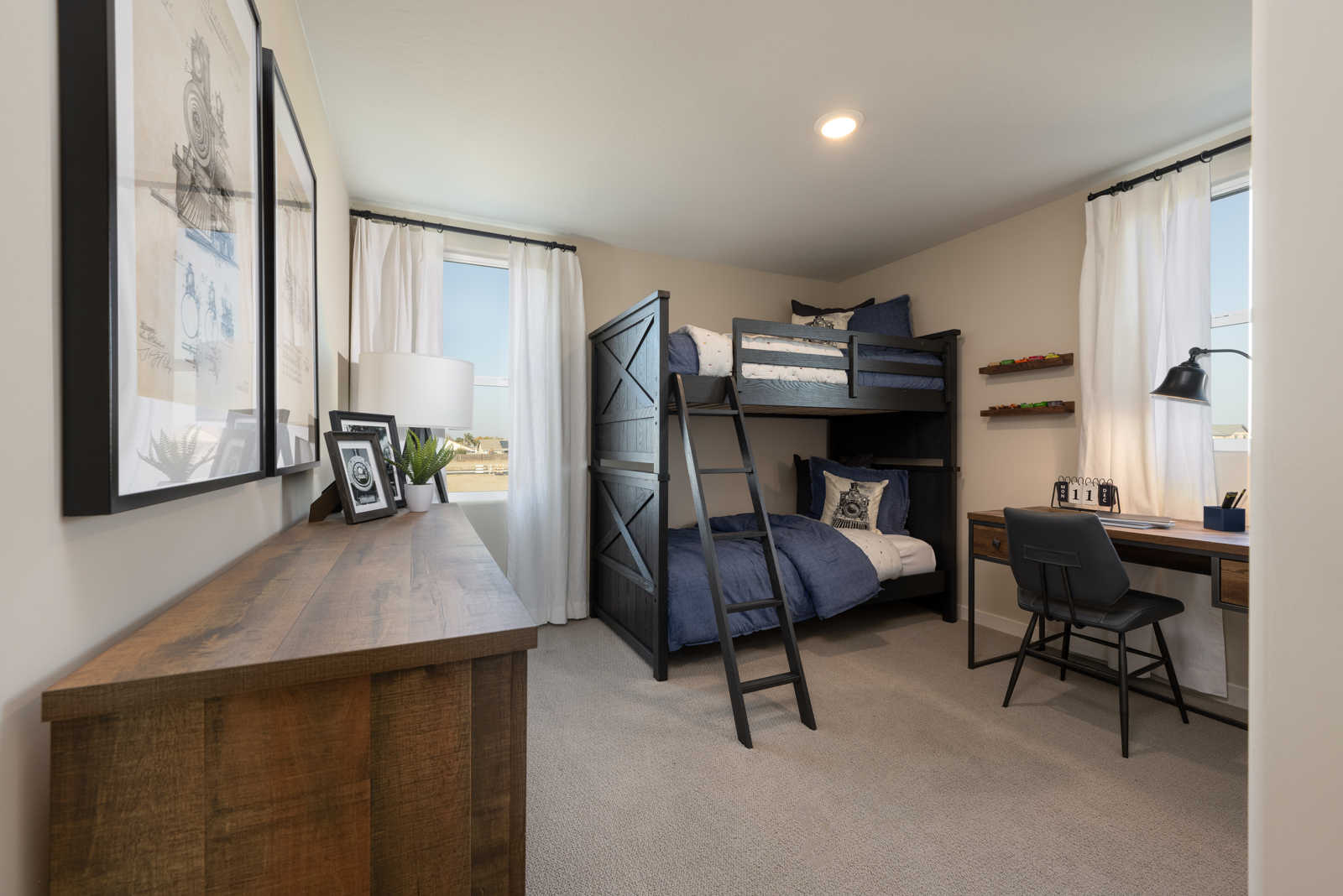 A room with a bed desk and a chair.