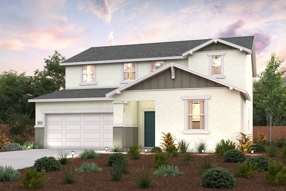 A house with a garage and bushes in front of it.