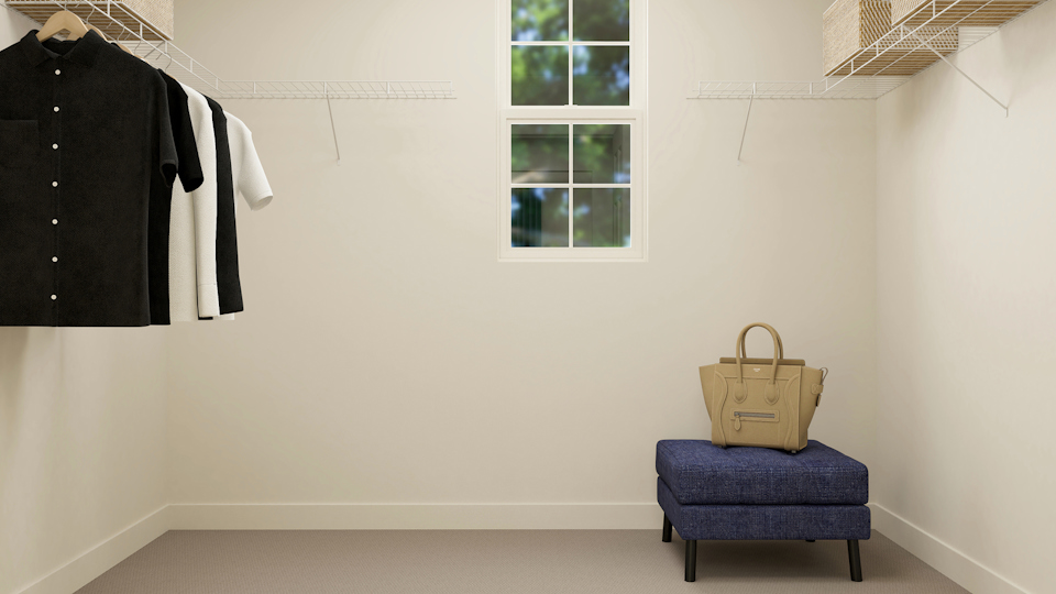 A room with a chair and clothes on the wall.