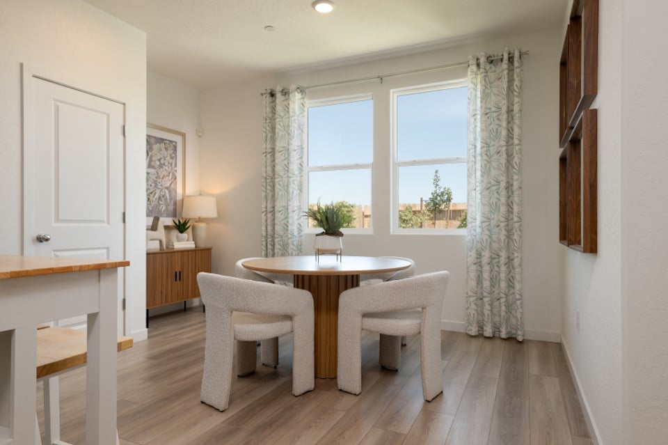 A dining room with a table and chairs.