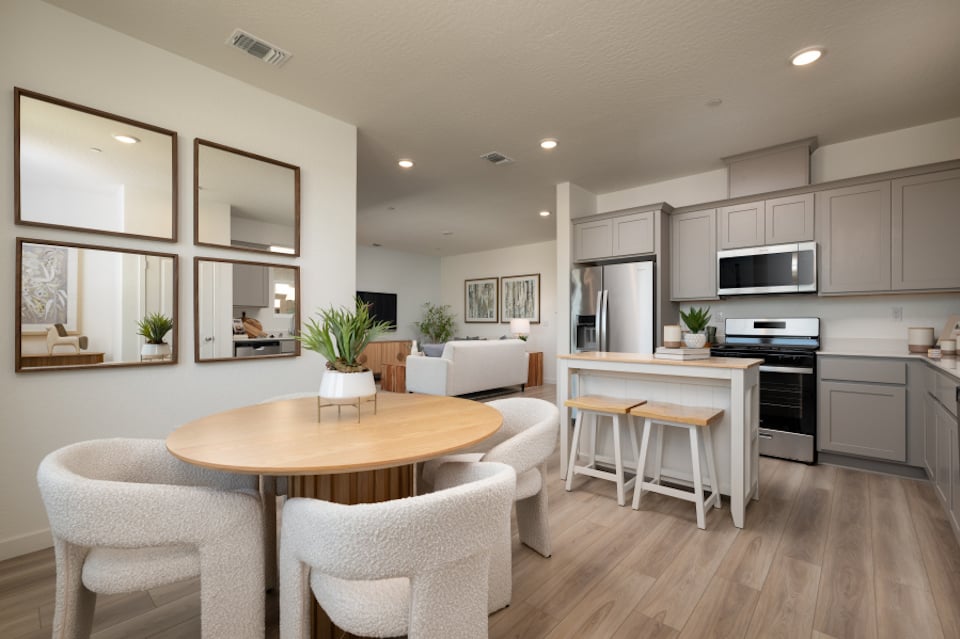 A kitchen with a table and chairs.