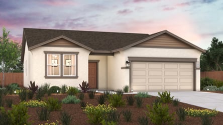 A house with a garage and a garden in front of it.