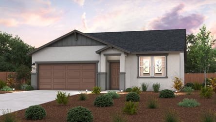 A house with a garage and bushes.