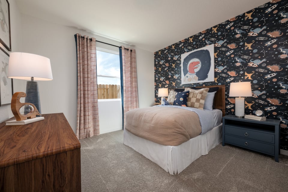 A bedroom with a bed and lamps.