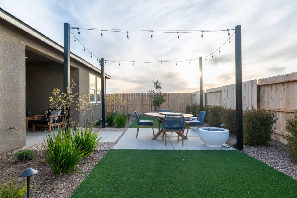 A backyard with a table and chairs.