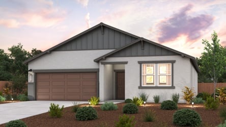 A house with a garage and bushes.