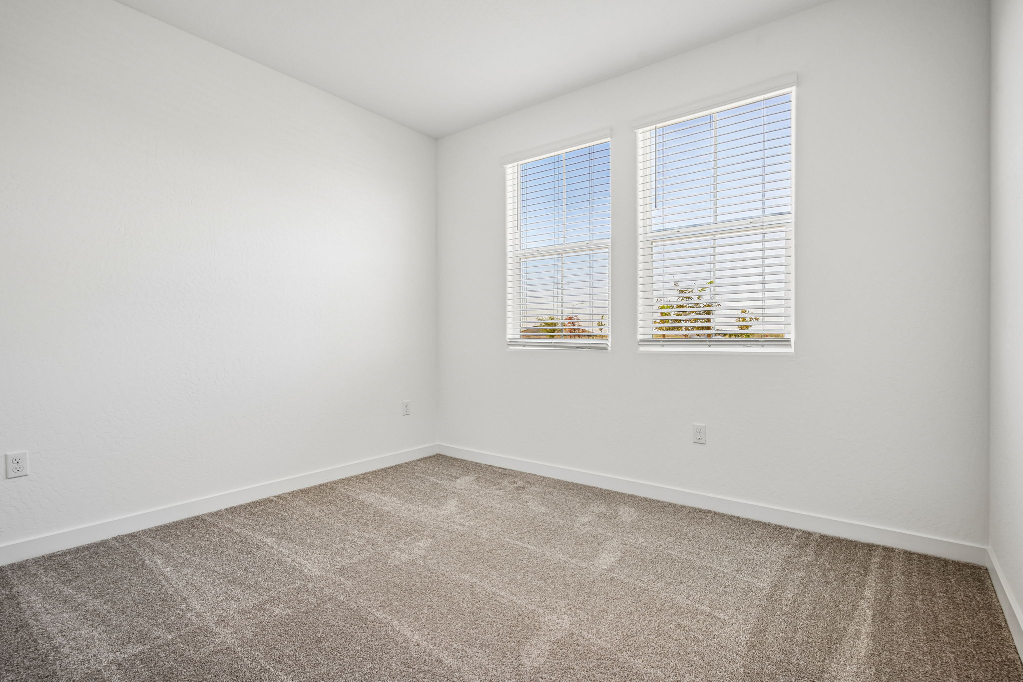 A room with a carpet and a window.
