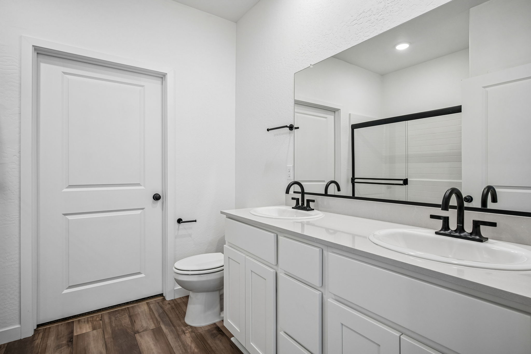 A bathroom with a sink toilet and mirror.
