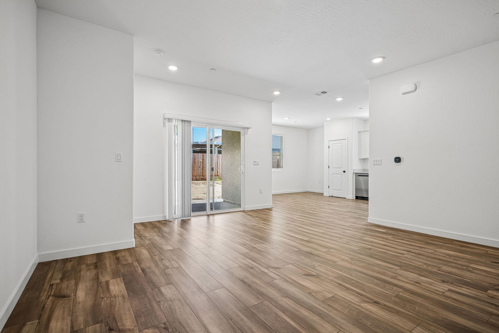 A room with white walls and wood floors.