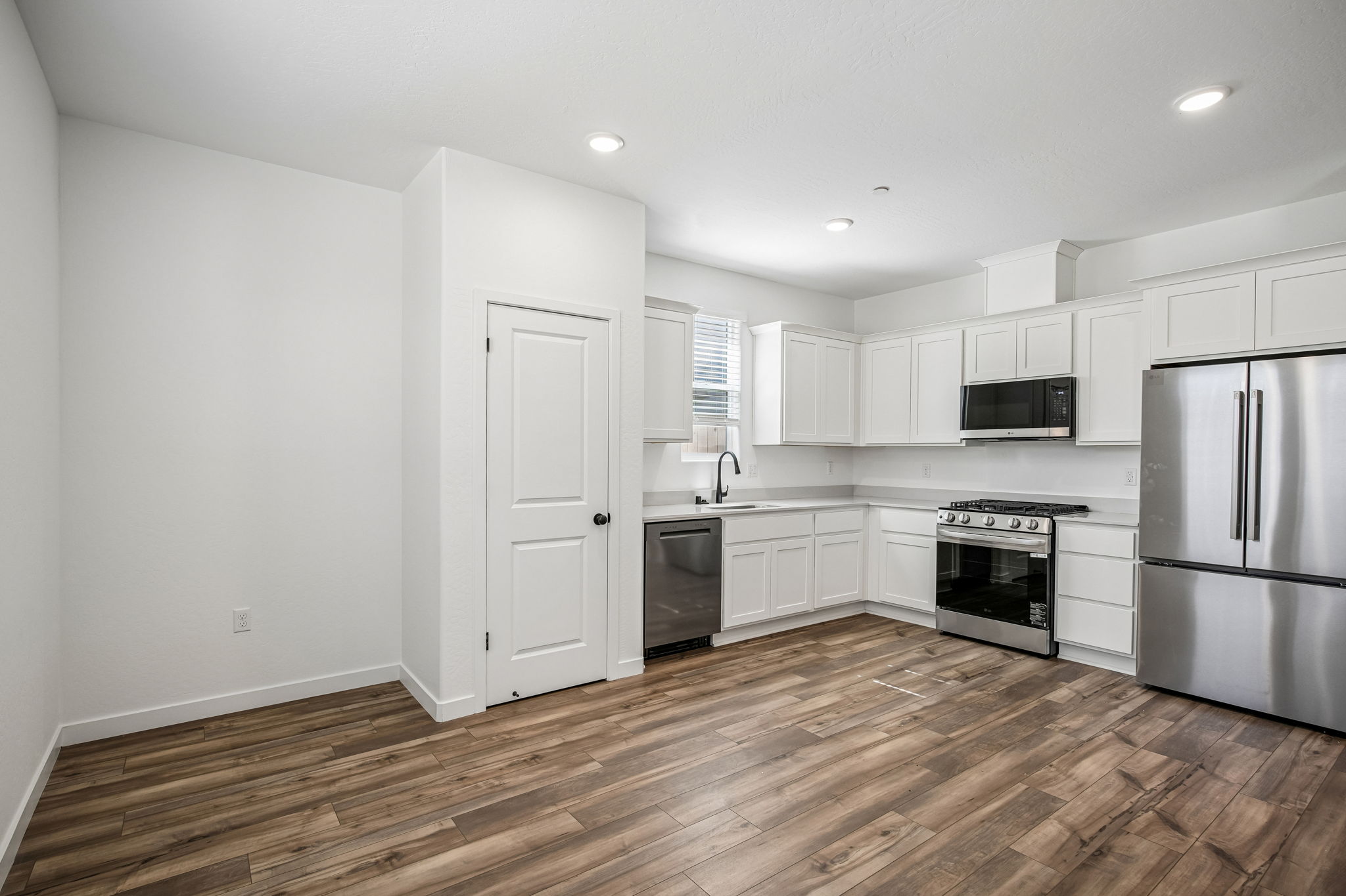 A kitchen with white cabinets.