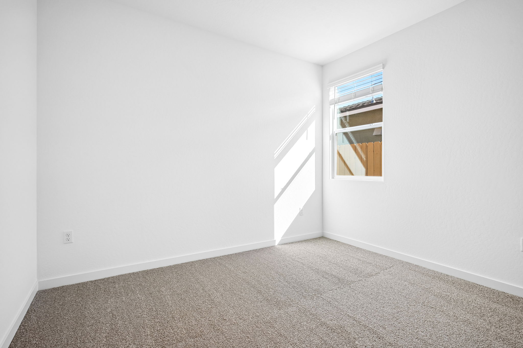 A room with a window and carpet.