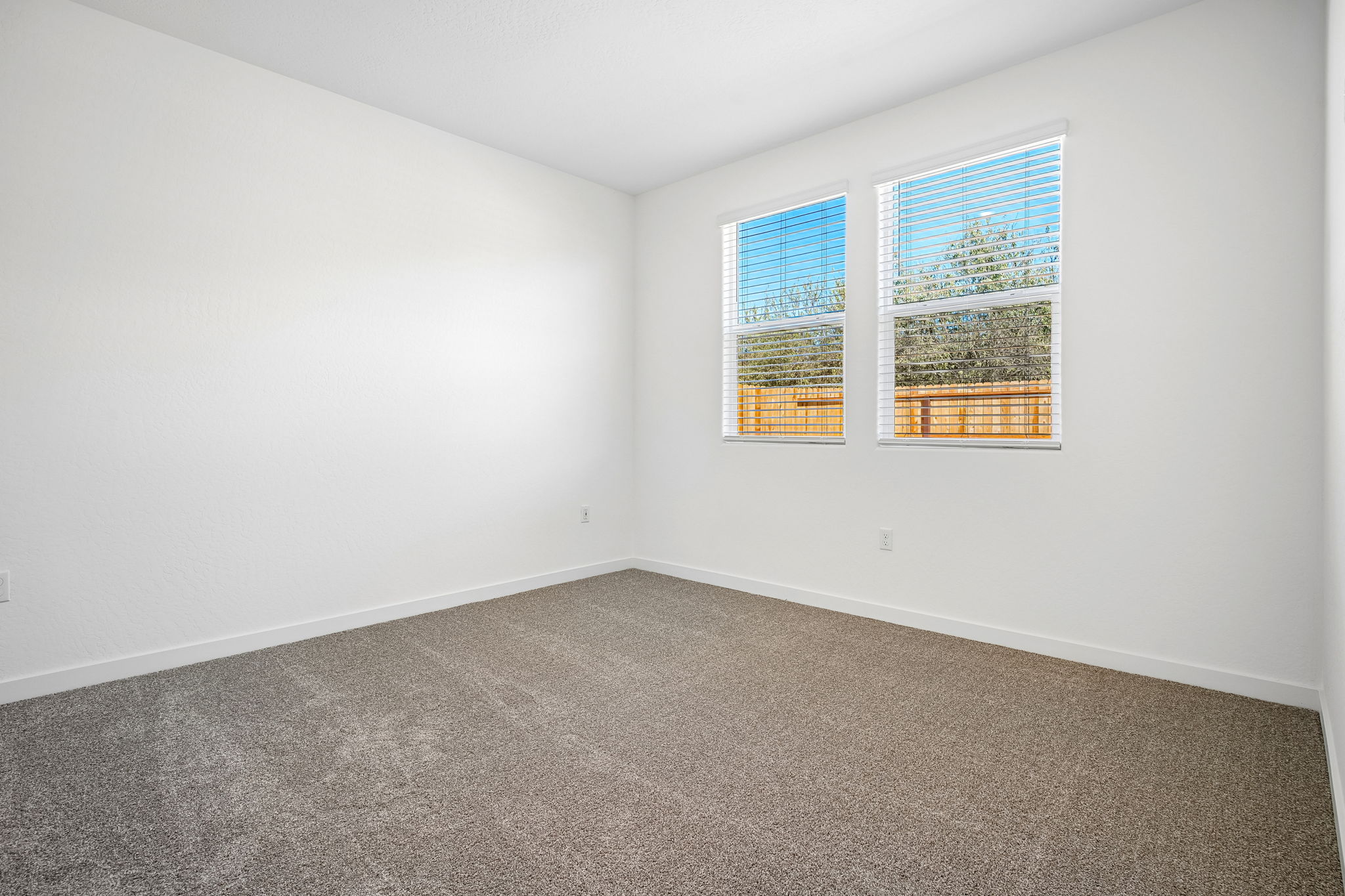 A room with a window and carpet.