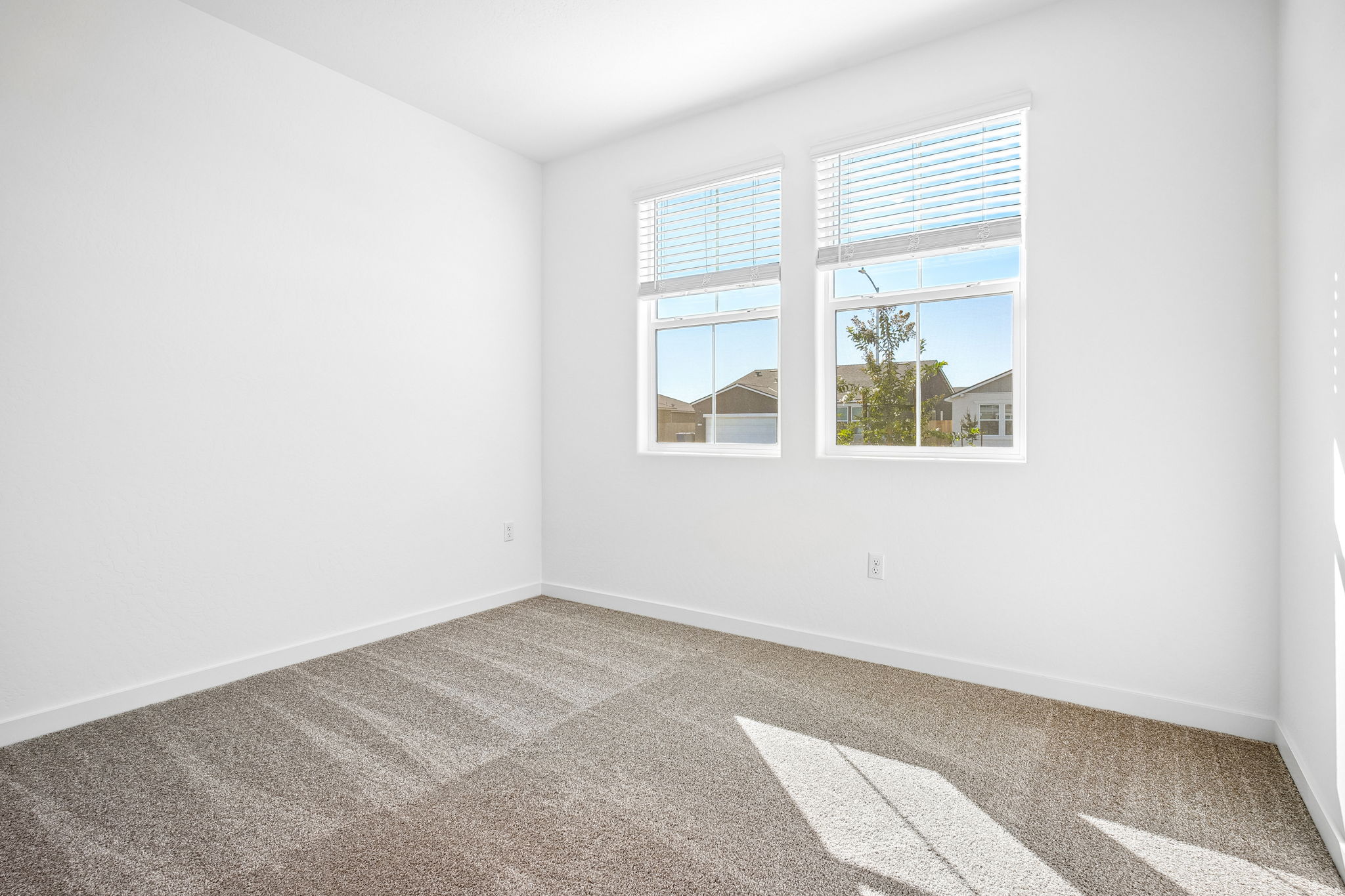 A room with a window and a rug.
