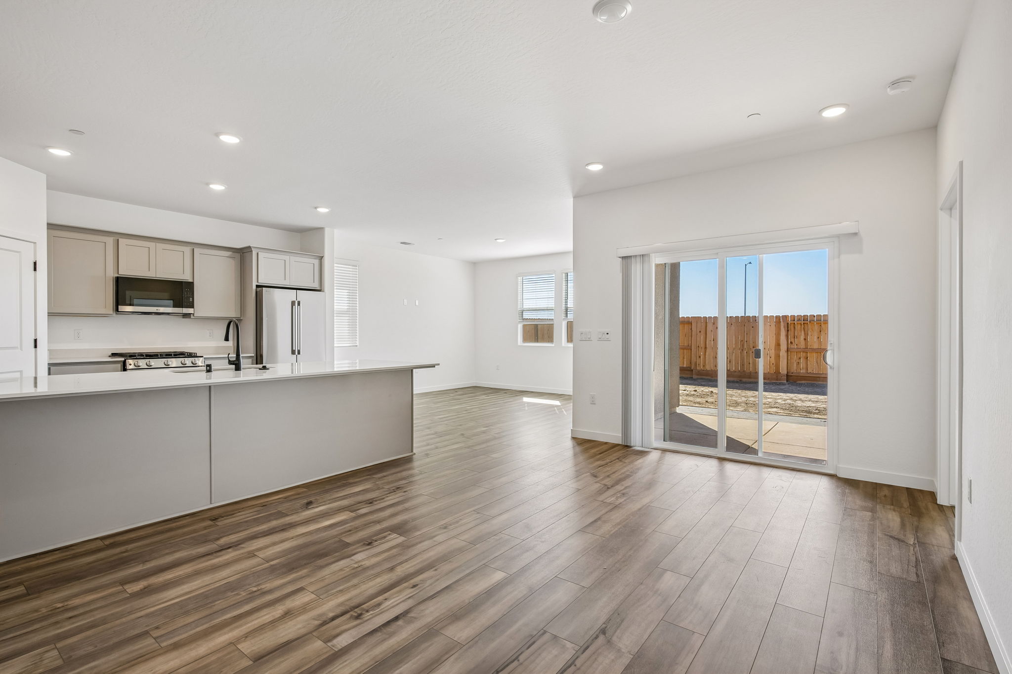 A large kitchen with a wood floor.