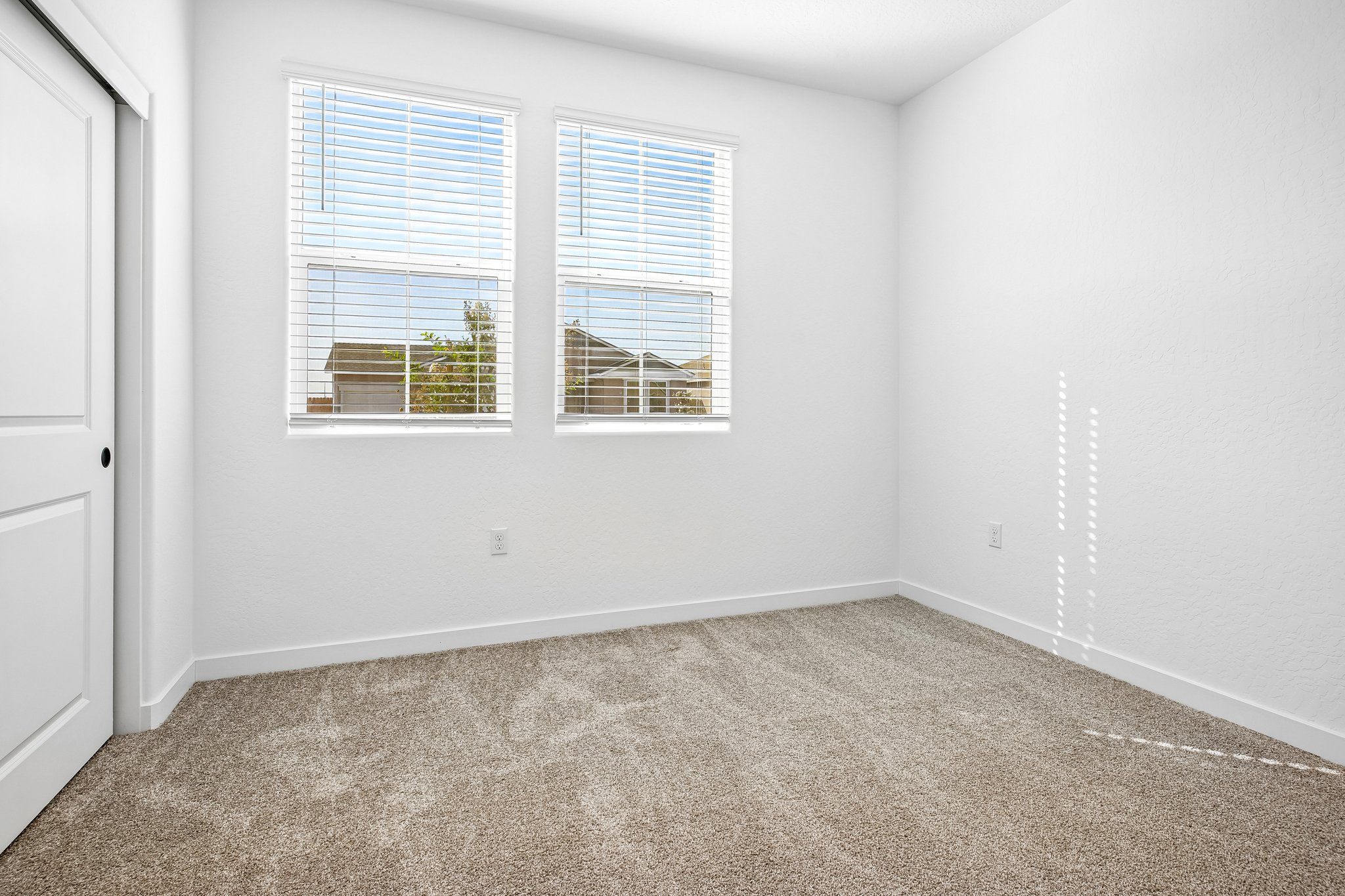 A room with a window and a carpet.
