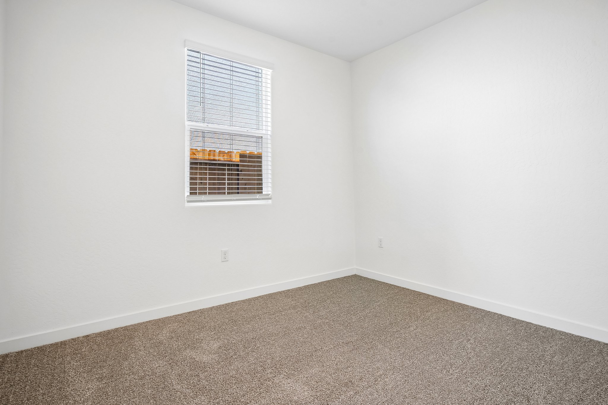 A room with a window and carpet.