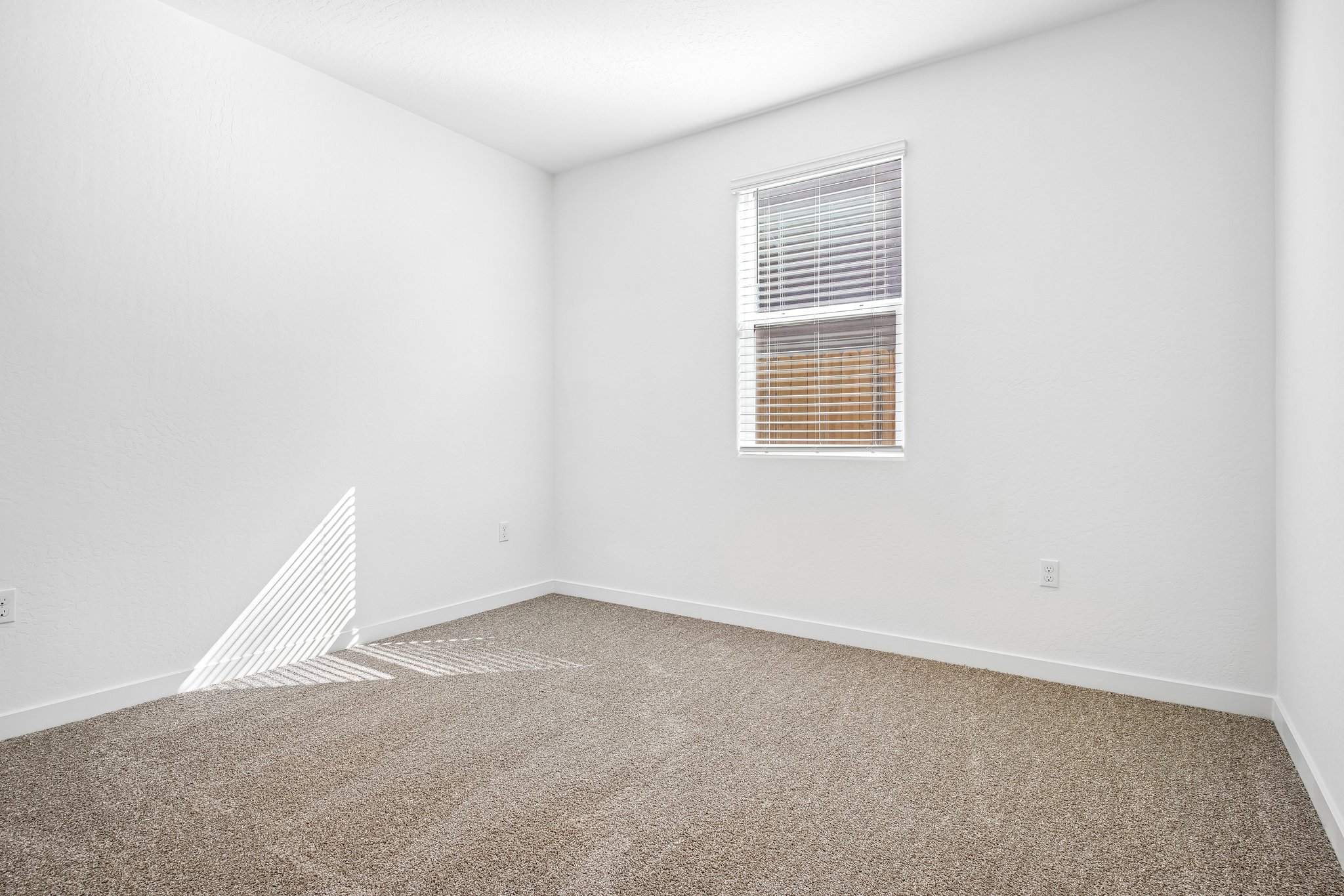A room with a window and carpet.