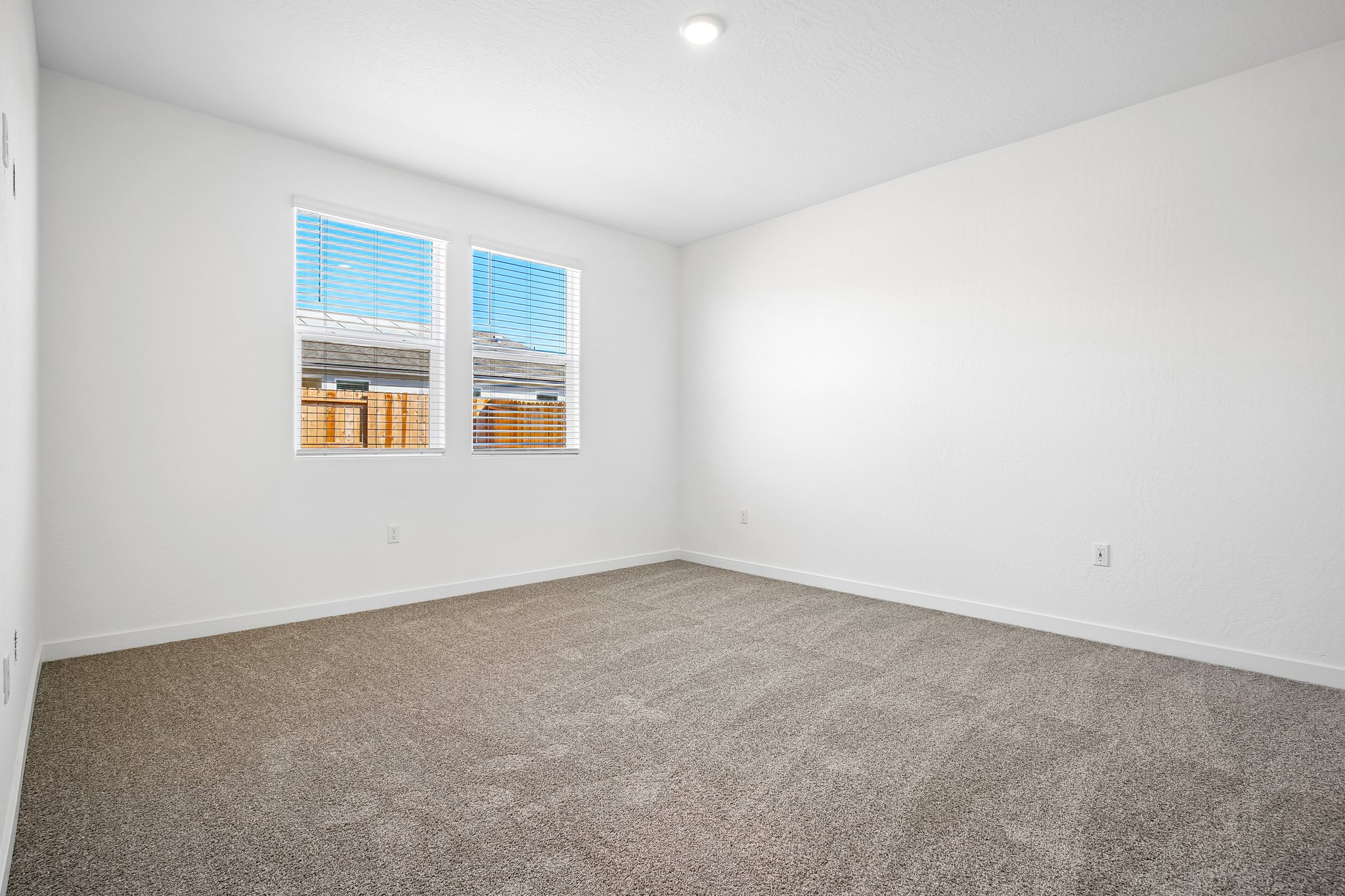 A room with a carpet and a window.