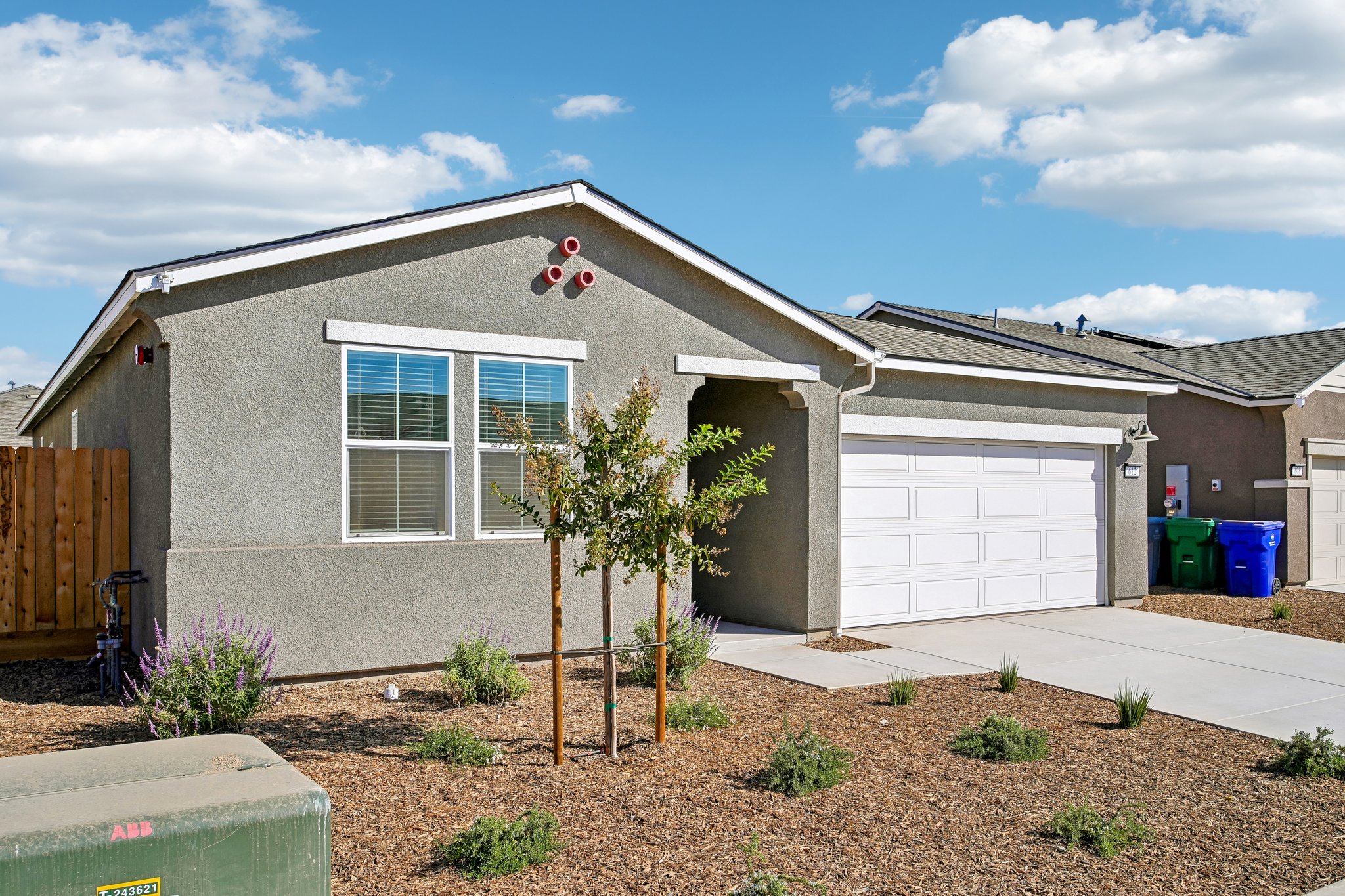 A house with a garage and a tree in the front.