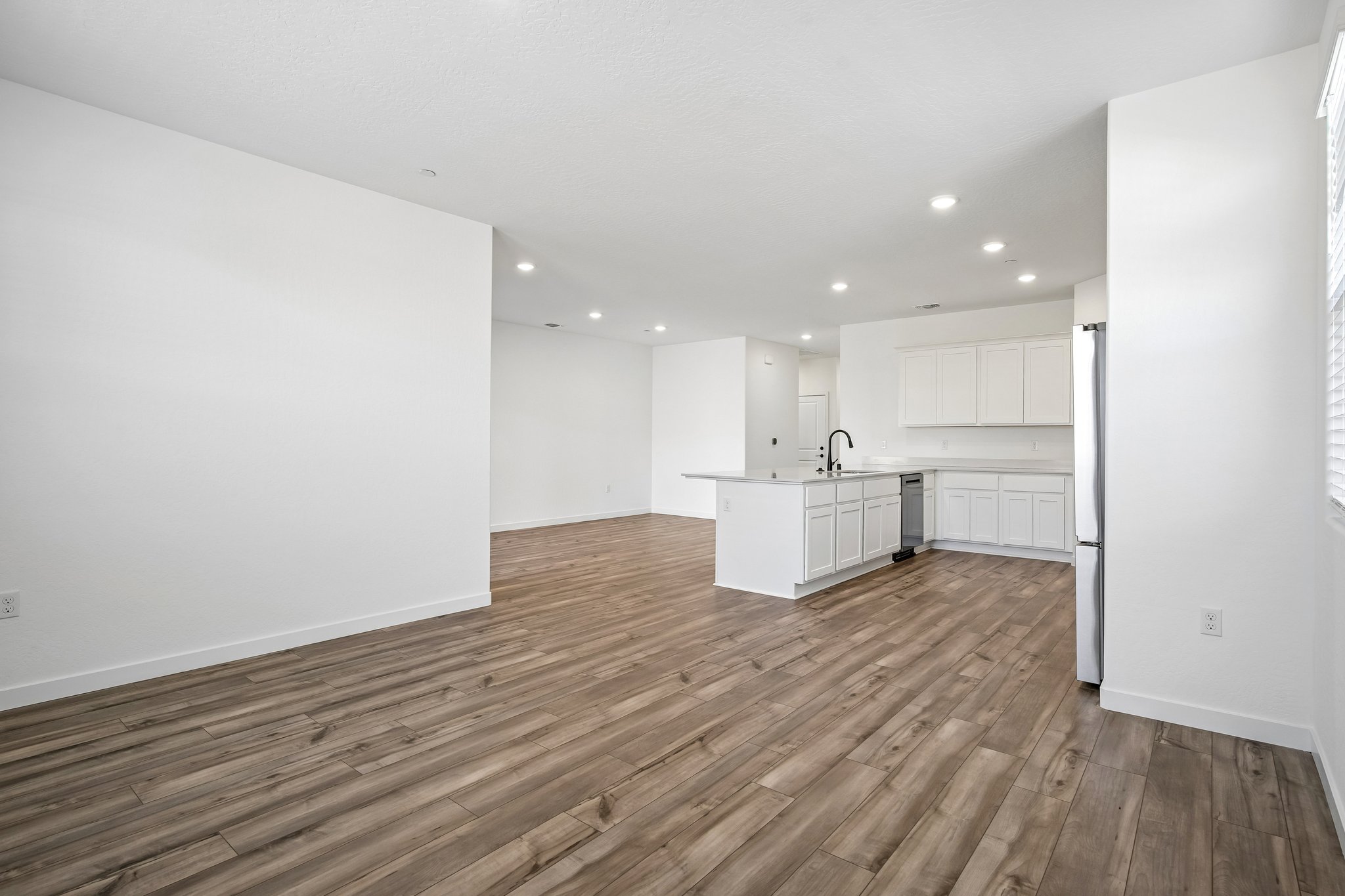 A room with white walls and wood floors.