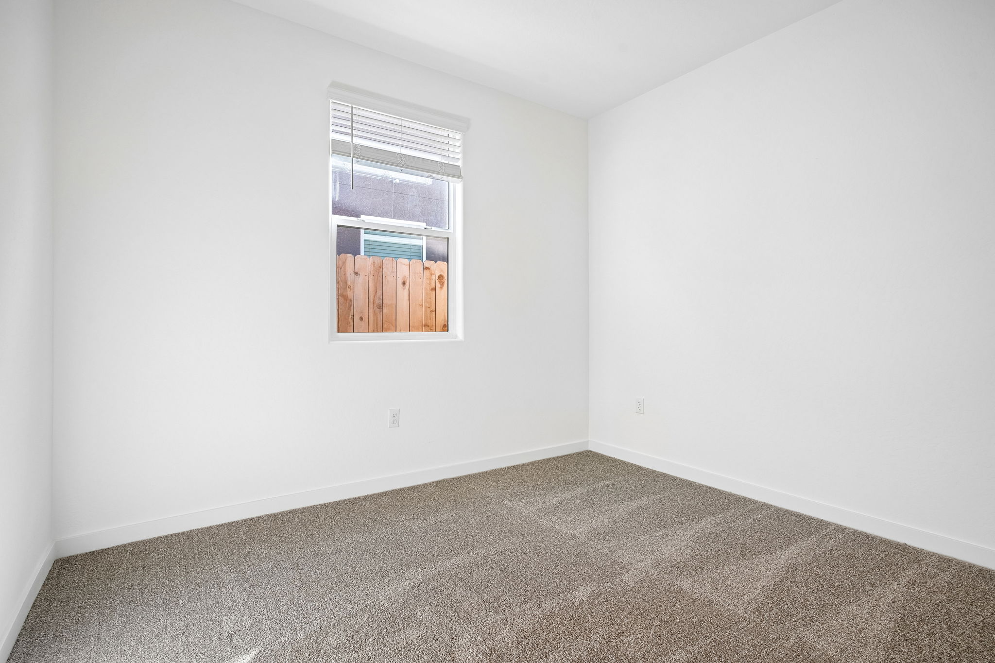 A room with a window and carpet.