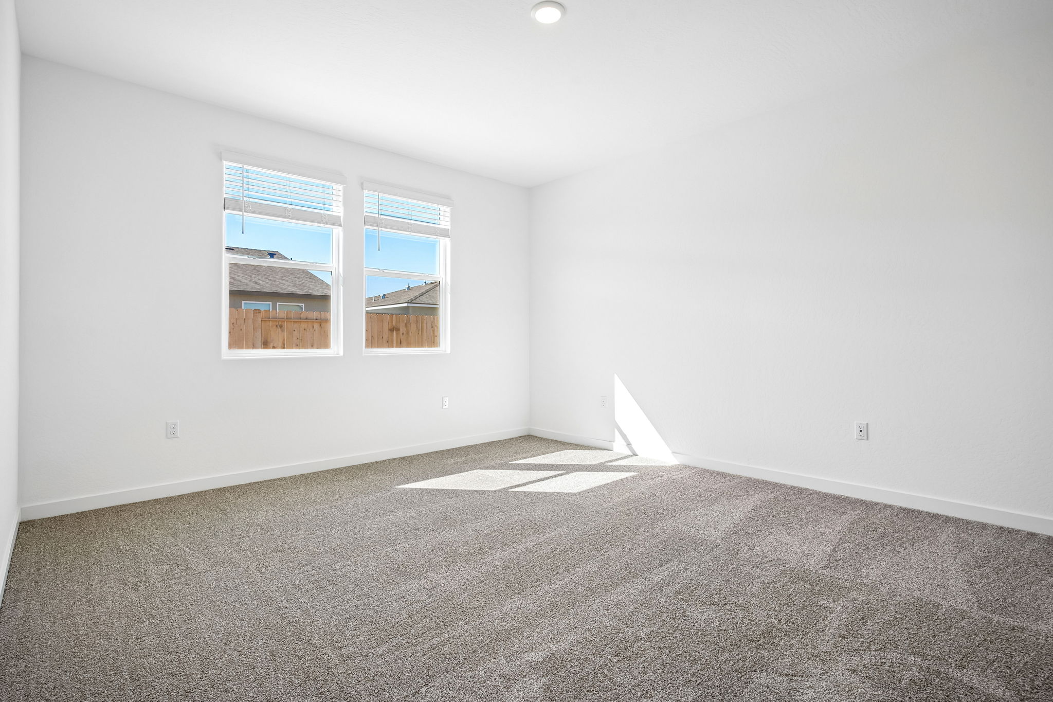 A room with a window and carpet.