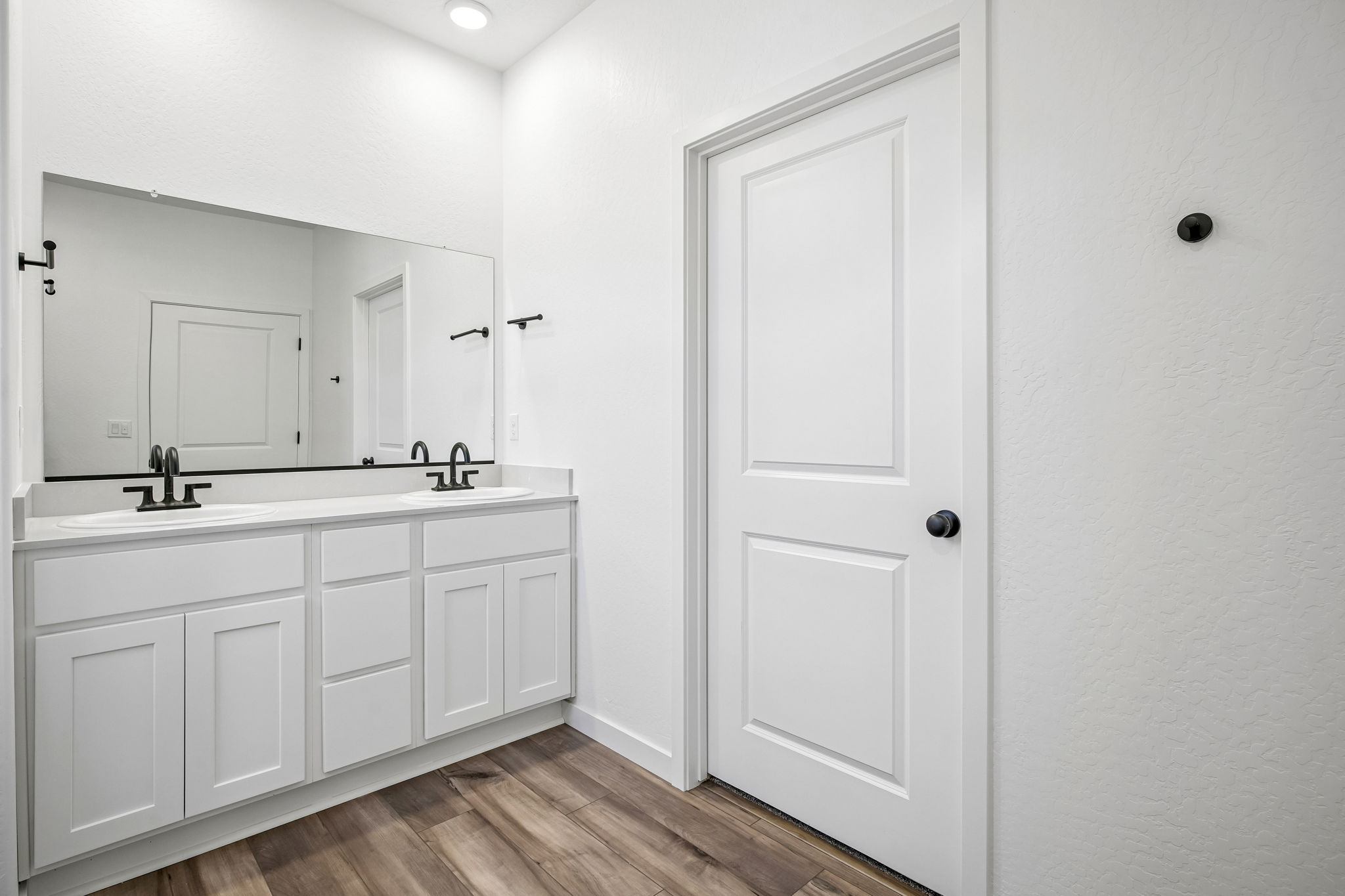 A bathroom with white cabinets.