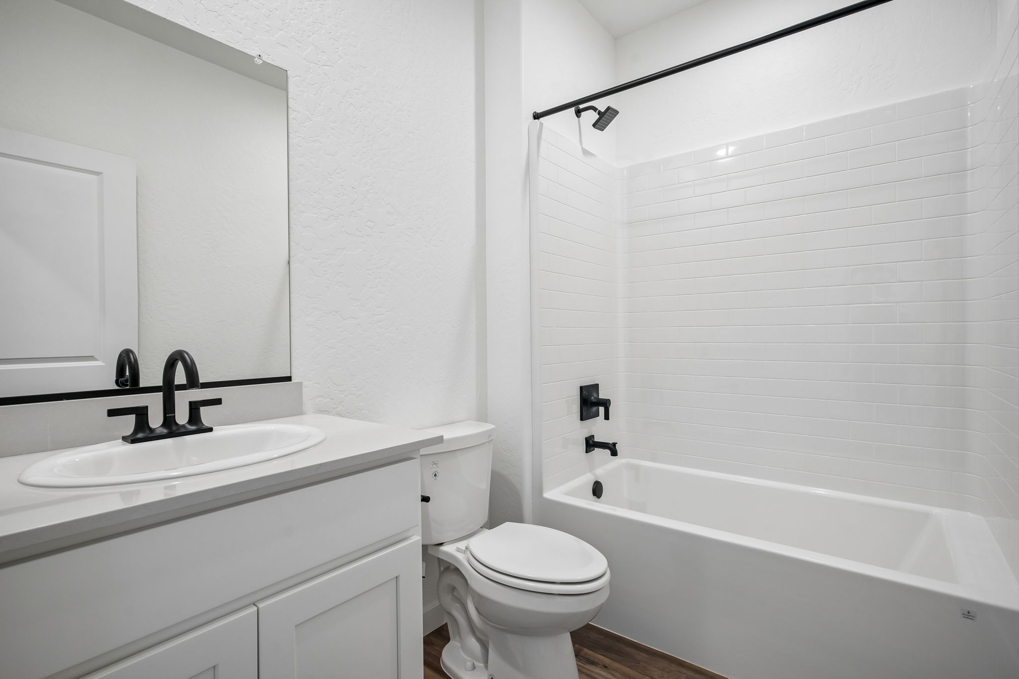A bathroom with a tub sink and toilet.