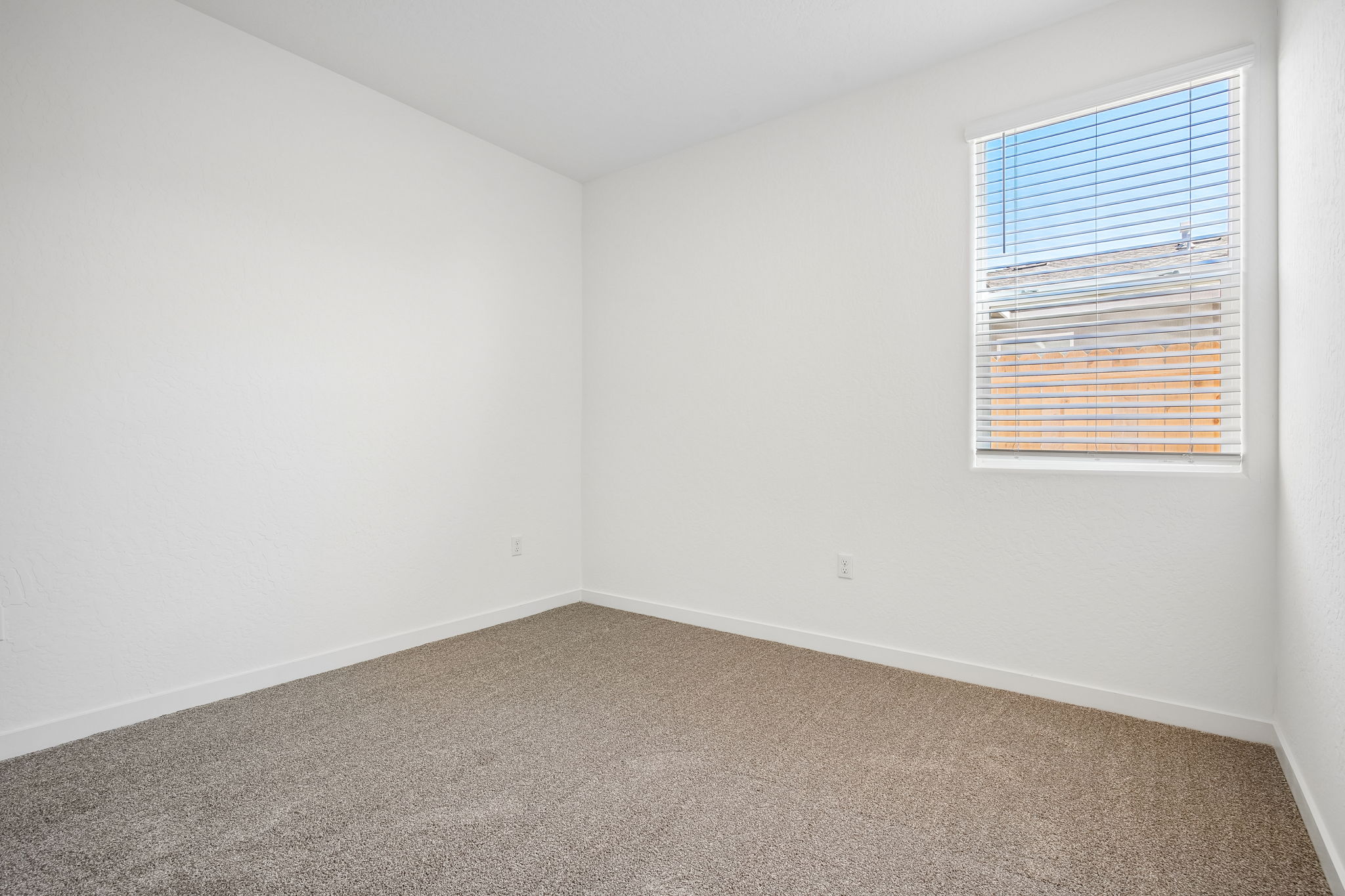 A room with a window and carpet.