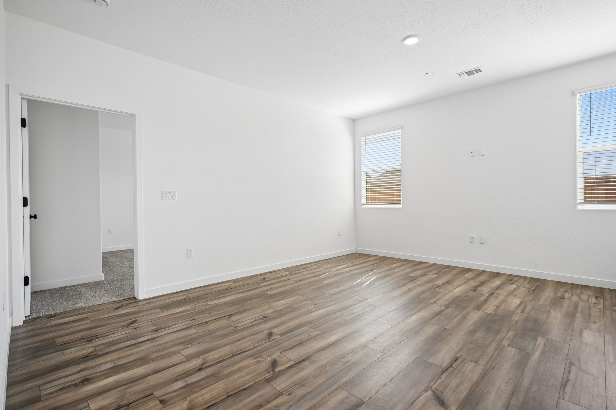 A room with a wood floor and white walls.