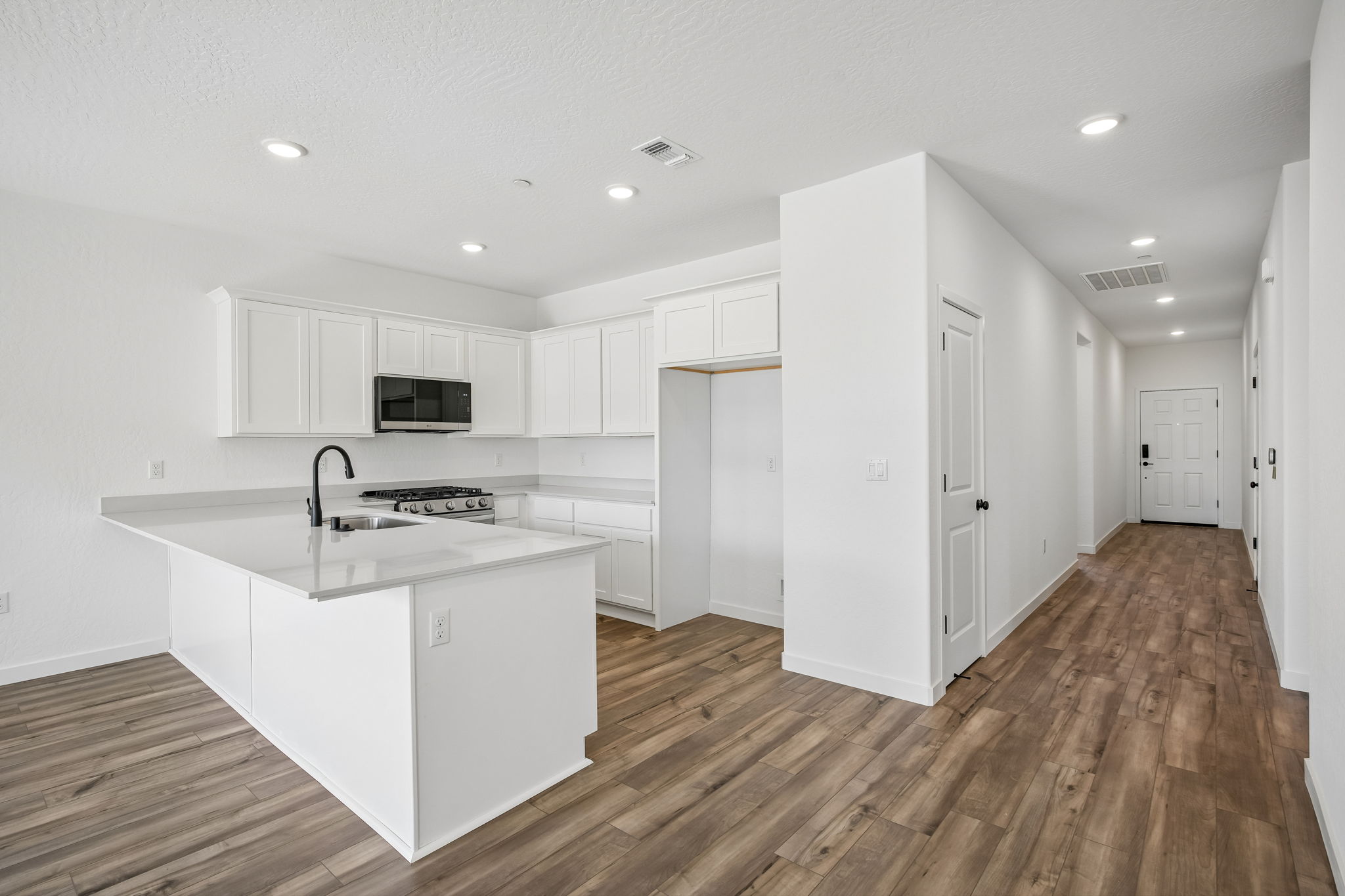 A kitchen with white cabinets.