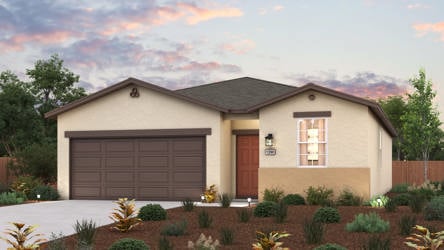 A house with a garage and bushes in front of it.