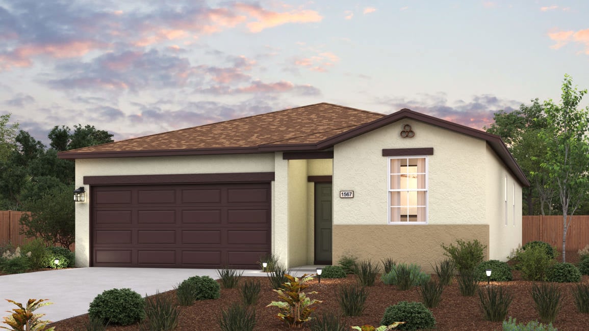 A house with a garage and bushes.