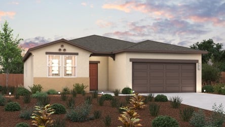 A house with a garage and bushes in front of it.