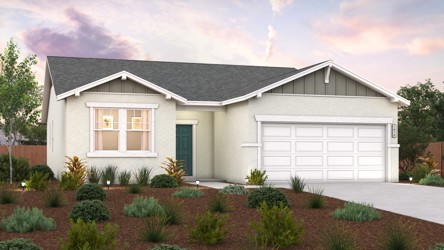 A house with a garage and bushes in front of it.