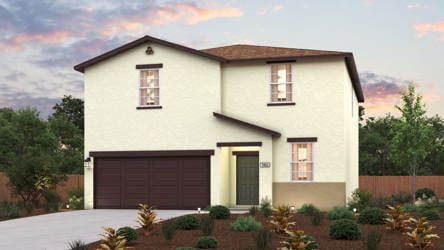A house with a garage and bushes in front of it.