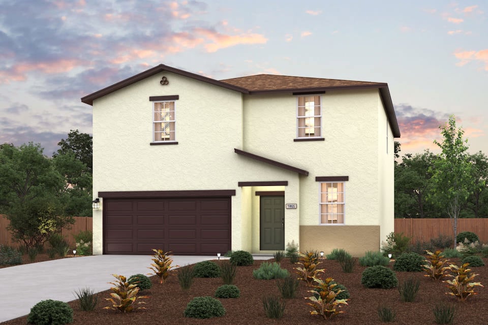 A house with a garage and bushes in front of it.