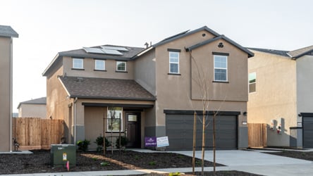 A building with a tree in front.