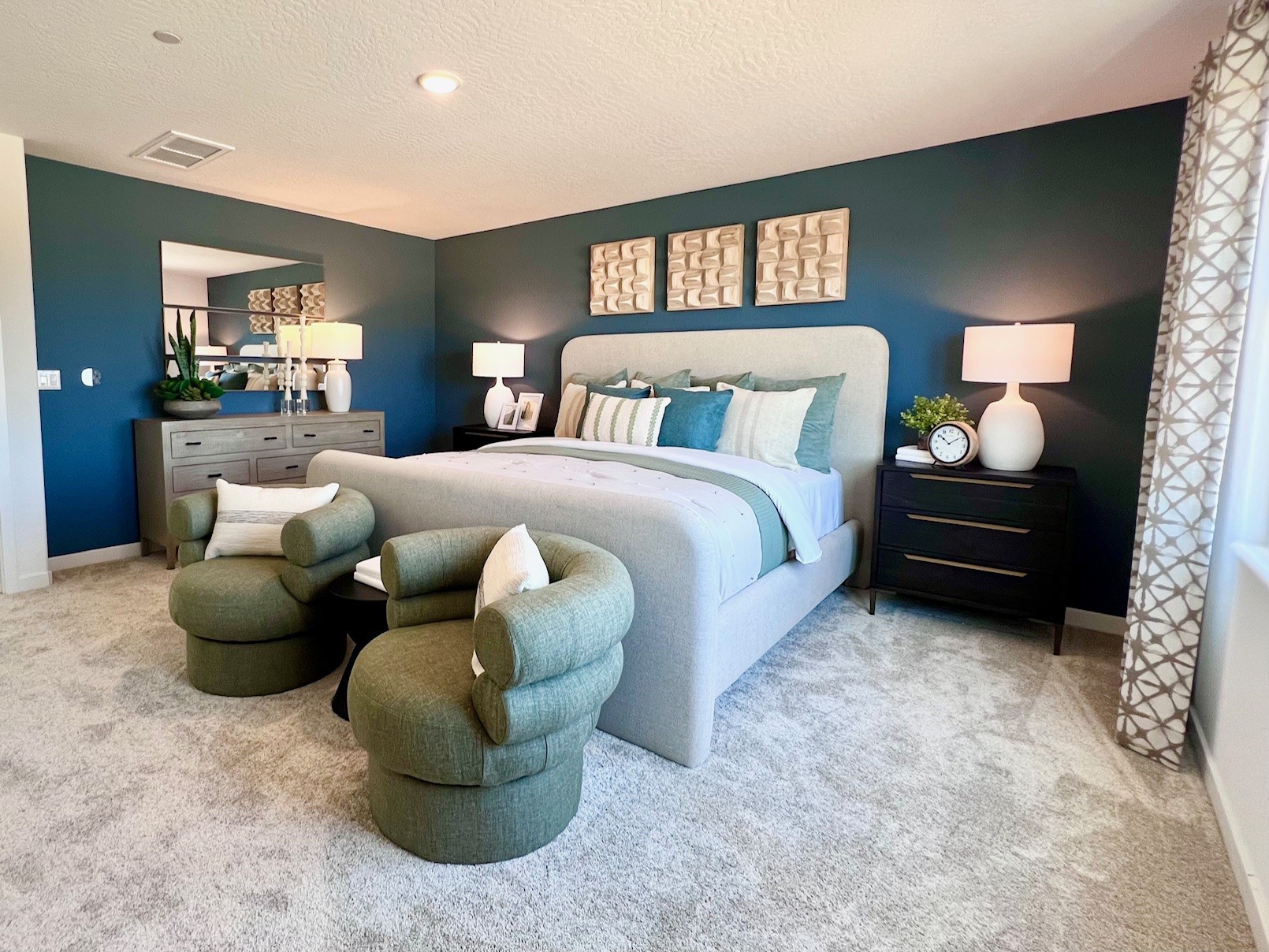 A bedroom with a couch and chairs.