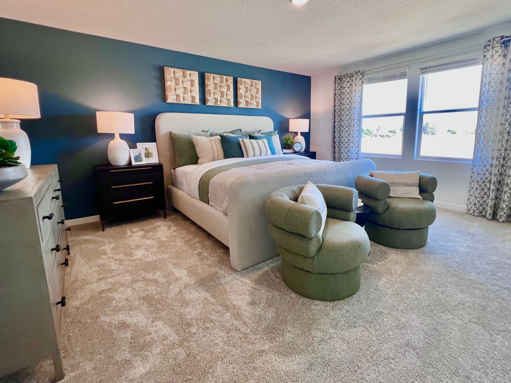 A bedroom with a couch and chairs.