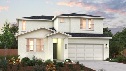 A house with a garage and bushes in front of it.