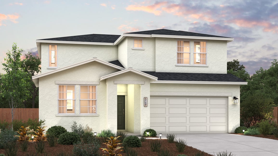 A house with a garage and bushes in front of it.